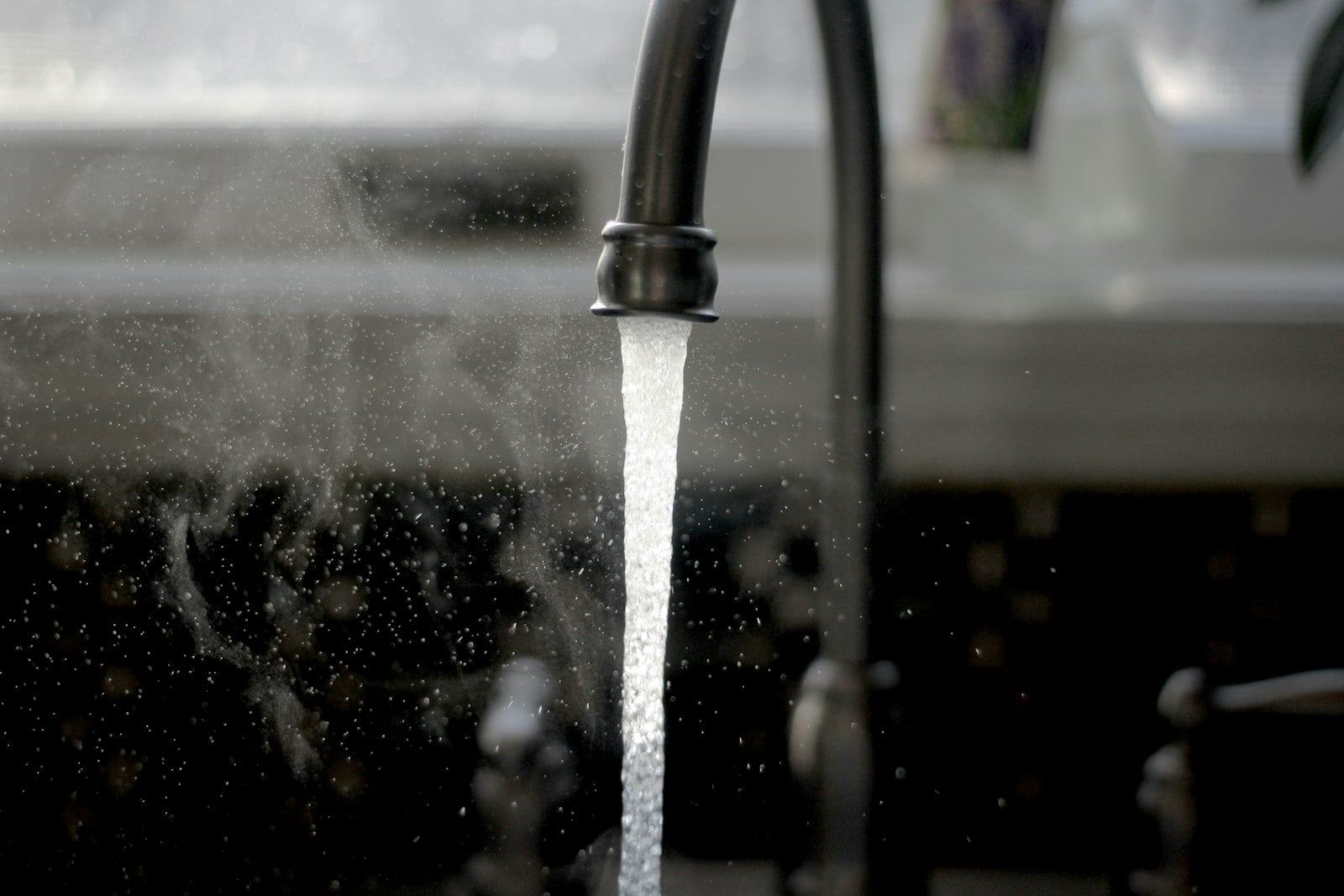 Kitchen faucet running water into a sink